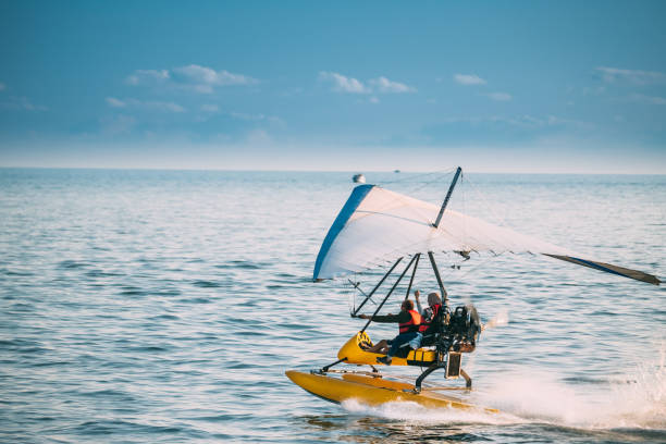 Batumi, Adjara, Georgia. Motorized Hang Glider With Muslim Woman Take Off Frow Sea In Sunny Summer Day Batumi, Adjara, Georgia - September 10, 2017: Motorized Hang Glider With Muslim Woman Take Off Frow Sea In Sunny Summer Day. Muslim People Having Fun para ascending stock pictures, royalty-free photos & images