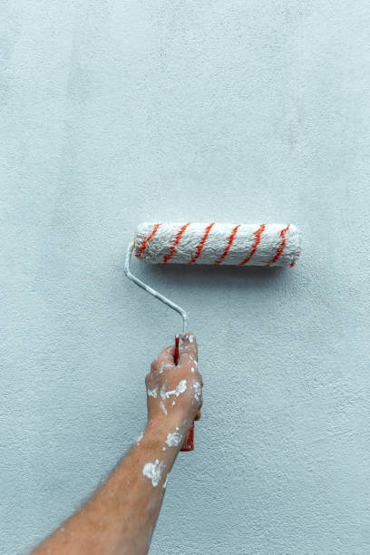 istock Painter Hand Paints The Wall With Paint Roller, Close-up With Copy-Space. Home Renovation Concept 961701716