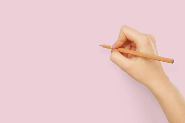 istock Male hand holding black pencil isolated on white 961705210