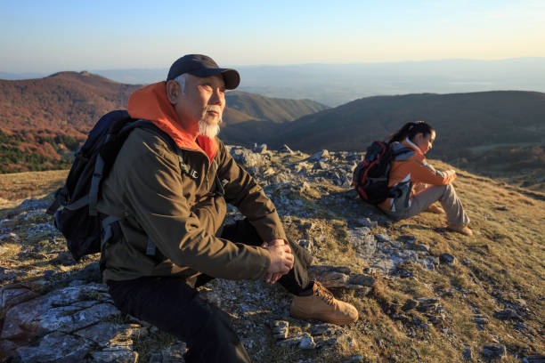 istock Couple hikers sitting on top mountain and resting 961706358