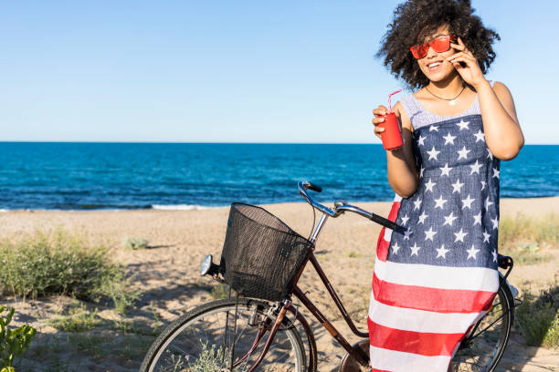 istock Carefree african woman drinking red can on beach 961709082