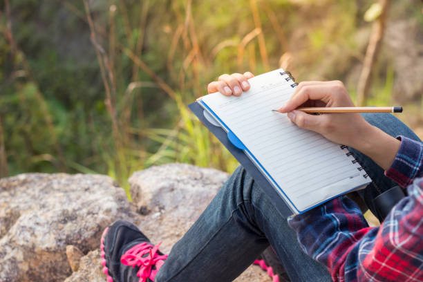 istock Female hiker write notes Nature trails, mountains, forests. Writer 961713194