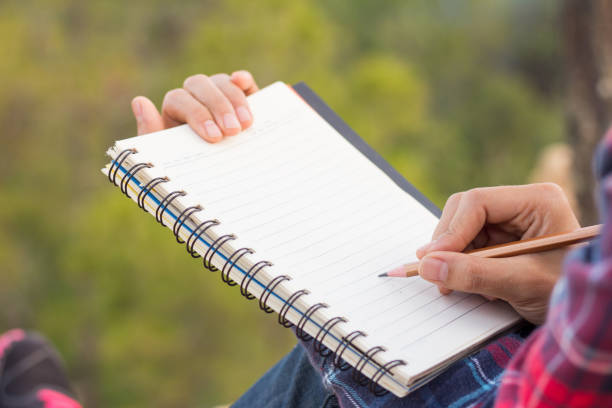 istock Female hiker write notes Nature trails, mountains, forests. Writer 961713210