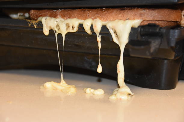 Yellow cheese dripping from a toaster