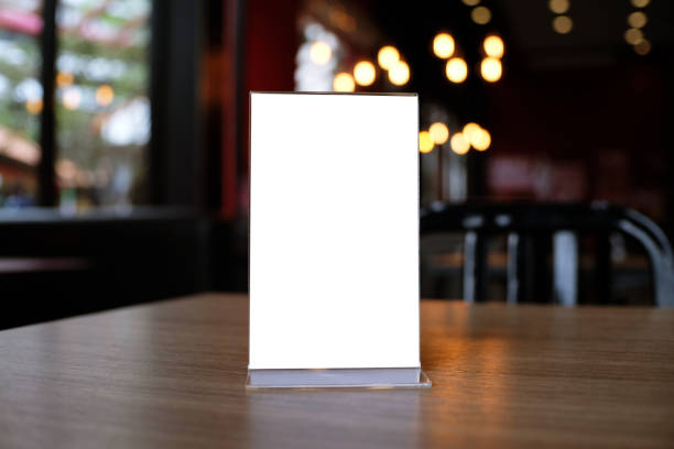 Mock up Menu frame standing on wood table in Bar restaurant cafe. space for text Mock up Menu frame standing on wood table in Bar restaurant cafe. space for text. restaurant table card stock pictures, royalty-free photos & images