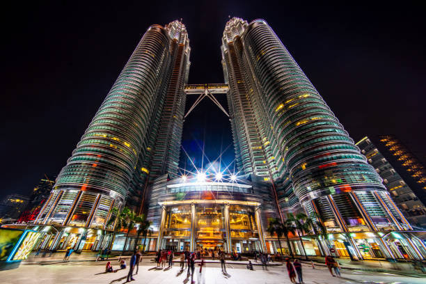 Petronas Twin Towers at Night Kuala Lumpur View from the entrance up to the iconic illuminated Petronas Twin Towers in Downtown Kuala Lumpur at Night. Ultra Wide Angle Architecture Shot. Kuala Lumpur, Malaysia, Asia. twin towers malaysia stock pictures, royalty-free photos & images