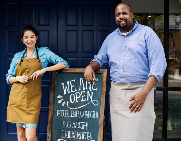 istock Cheerful business owners standing with open blackboard 961719762