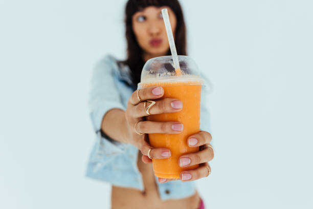 женщина предлагает свежий апельсиновый сок - smoothie fruit orange juice стоковые фото и изображения
