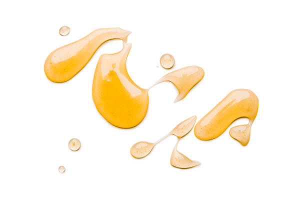 miele liquido isolato su sfondo bianco - miele dolci foto e immagini stock