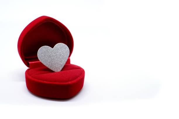Silver glitter heart in wedding ring box. Valentines day present concept.