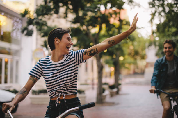 couple enjoying cycling through city - cycling bicycle hipster urban scene imagens e fotografias de stock