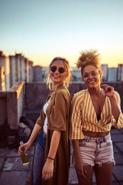 Two women dancing at the party. Two women dancing and drinking alcohol at the roof party. woman drinking beer stock pictures, royalty-free photos & images
