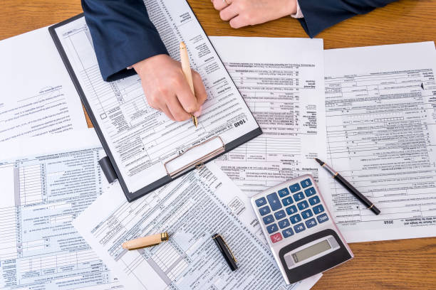 widok z góry kobiecego wypełnienia dłoni 1040 - tax tax form financial advisor calculator zdjęcia i obrazy z banku zdjęć