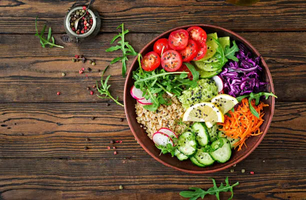 Photo of Vegetarian Buddha bowl with quinoa and fresh vegetables. Healthy food concept. Vegan salad. Top view. Flat lay