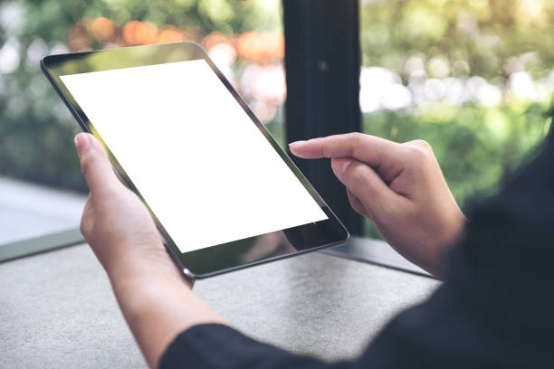 istock hands holding and pointing at a black tablet pc with blank white desktop screen 961731104