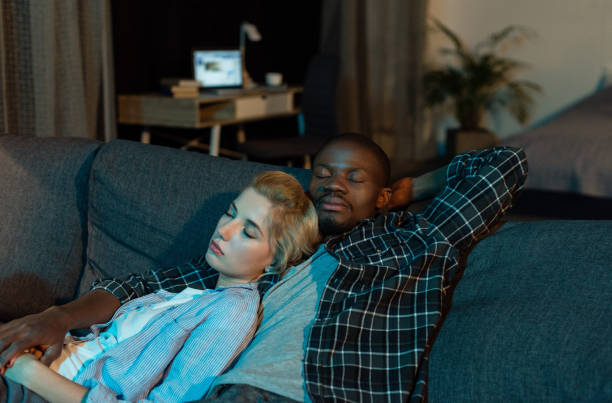 istock multicultural couple sleeping on sofa together at home 961735554