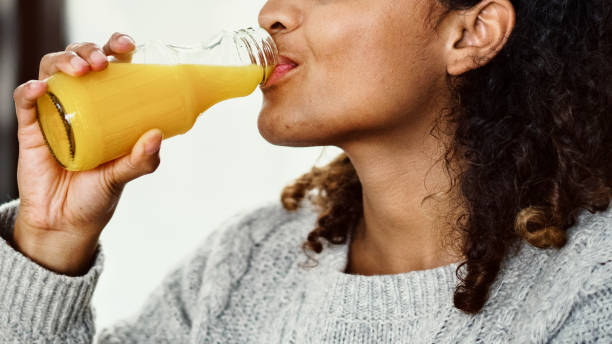 Woman drinking fresh orange juice Woman drinking fresh orange juice fruit juice stock pictures, royalty-free photos & images