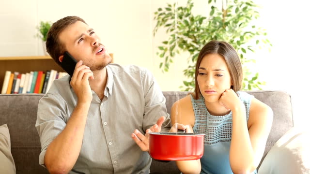 Upset couple calling insurance watching home leaks