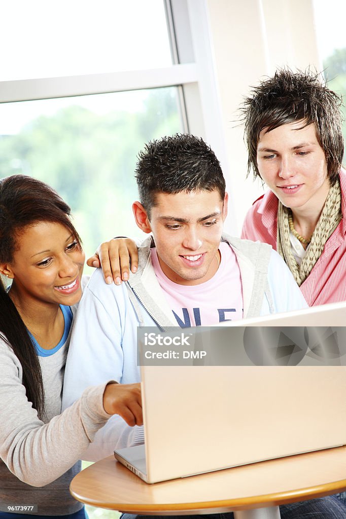 Three teenage students working on laptop in school  High School Student Stock Photo