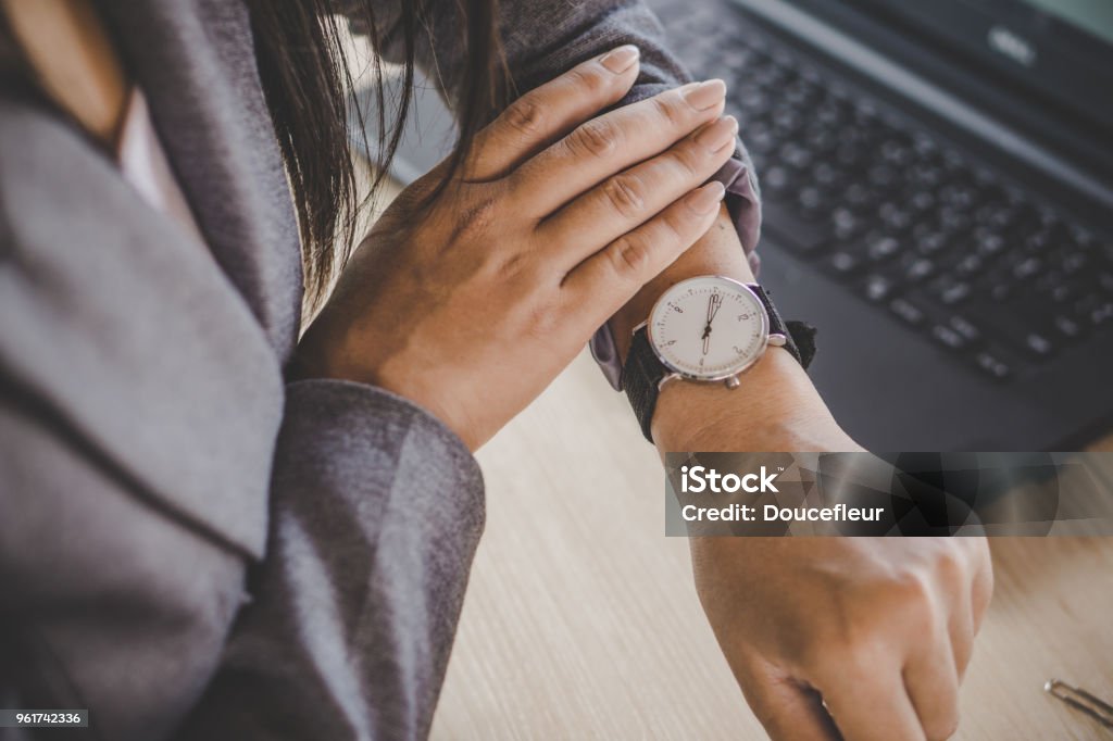businesswoman checking the time on watch businesswoman checking the time on watch at her office waiting for someone coming late Checking the Time Stock Photo