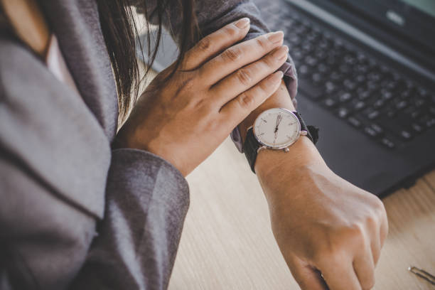 businesswoman checking the time on watch - esperar imagens e fotografias de stock