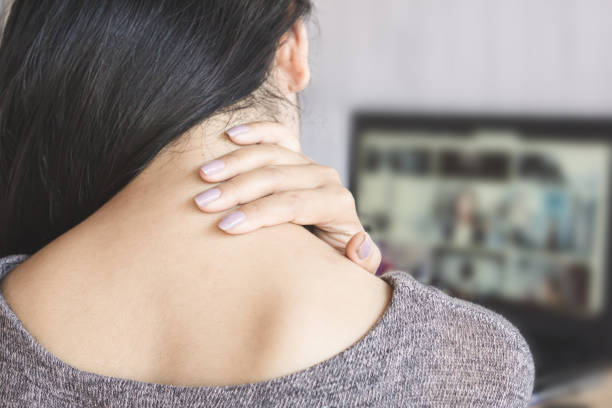 컴퓨터 노트북에서 작업 하는 동안 목에 통증이 있는 여성 - 목통증 뉴스 사진 이미지
