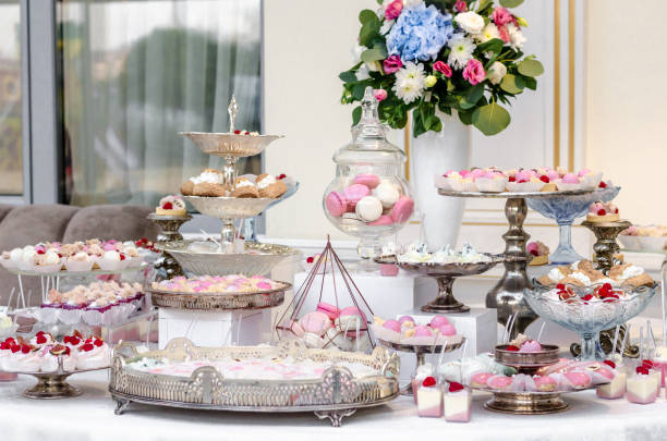 istock Delicious wedding reception candy bar dessert table full with cakes and sweets and a flower vase with hydrangeas. 961742408