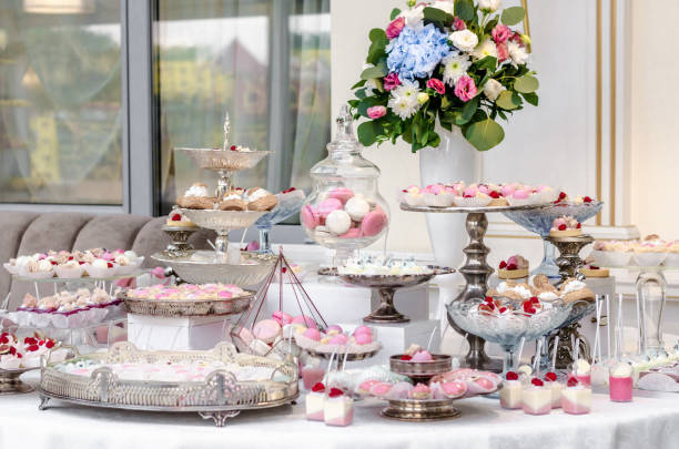 istock Delicious wedding reception candy bar dessert table full with cakes and sweets and a flower vase with hydrangeas. 961742498