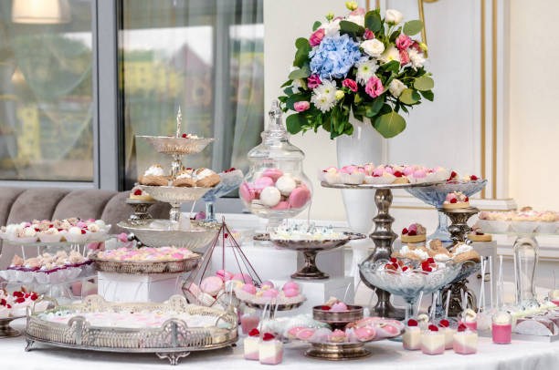 istock Delicious wedding reception candy bar dessert table full with cakes and sweets and a flower vase with hydrangeas. 961742502