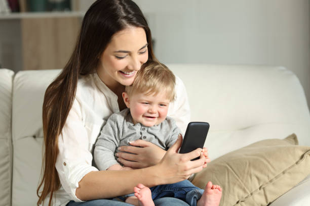 istock Mother and baby playing with a smartphone on a couch 961742736