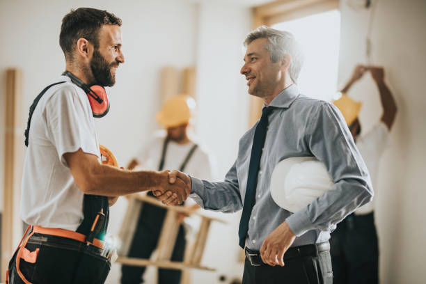 szczęśliwi pracownicy fizyczni potrząsając rękami z architektem na placu budowy. - maintenance engineer home improvement men manual worker zdjęcia i obrazy z banku zdjęć