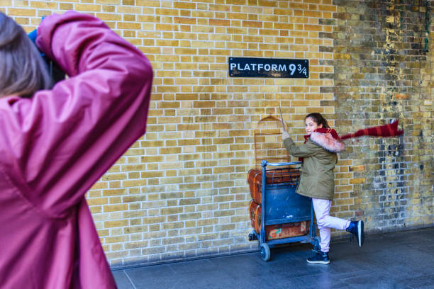 Harry Potter Platform nine and three quarters and trolley London, UK - February 24, 2018: Fan of Harry Potter recreates pushing a trolley towards platform nine and three quarters from the film. london girl stock pictures, royalty-free photos & images