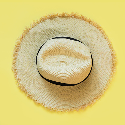 Looking down on a yellow and white sun hat on white background