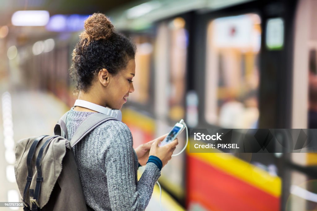 Young woman using mobile phone on subway 20-29 Years Stock Photo