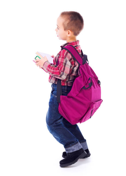 Little boy carrying big, heavy schoolbag full of books