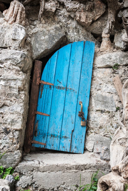 Old crooked blue wooden door in Crete, Greece Old crooked blue wooden door in Crete, Greece fairy door fairy tale antique stock pictures, royalty-free photos & images