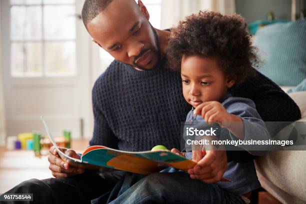 Father And Young Son Reading Book Together At Home Stock Photo - Download Image Now - Family, Child, Father