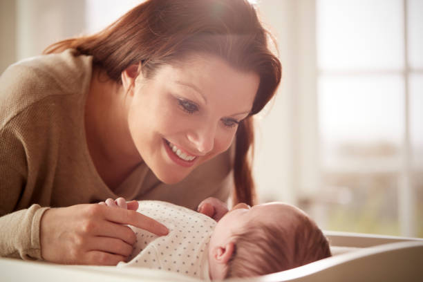 istock Mother Playing With Newborn Baby Lying On Changing Table 961758874