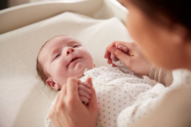 istock Mother Playing With Newborn Baby Lying On Changing Table 961758946