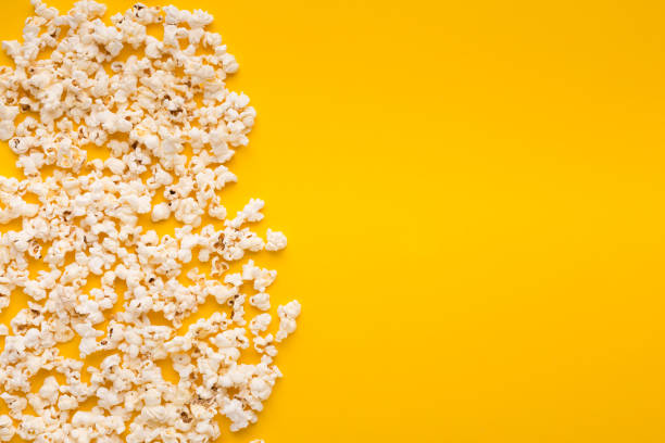 istock Slaty popcorn scattered on yellow background, top view 961759064