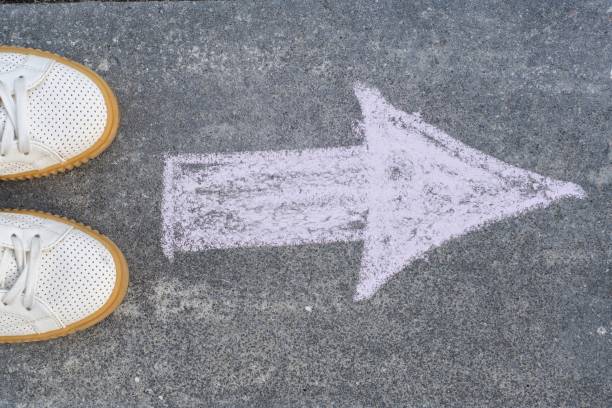 istock Feet and arrow on road. 961760398