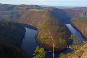 Panoramic view of river canyon with dark water and autumn colorful forest. Horseshoe bend, Vltava river, Czech republic. Beautiful landscape with river. Vyhlidka. Maj lookout.