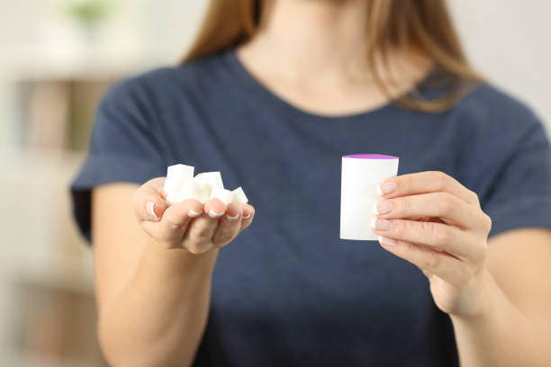 istock Woman hands holding sugar cubes and saccharin 961764378