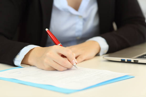 istock Closeup of an executive hands filling a form on a desktop 961764666