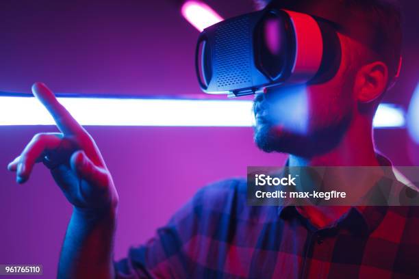 Man Choosing Options In Virtual Reality Stock Photo - Download Image Now - Virtual Reality Simulator, Virtual Reality, Neon Lighting