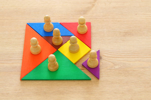 istock image of tangram puzzle blocks with chess figures over wooden table ,human resources and management concept. 961768816