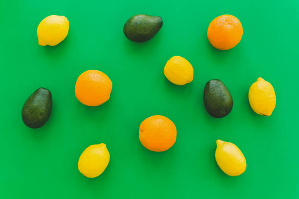 istock oranges, avocado and lemons on bright green paper trendy background, flat lay. modern summer image concept. multi fruit flat lay, juicy vitamin abstract background, pop art 961772982