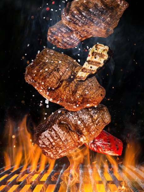istock Tasty beef steaks flying above cast iron grate with fire flames 961778716