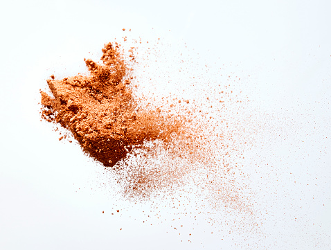 chocolate powder flying on white background