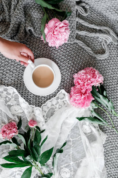 istock A cup of coffee and peonies on a gray background 961782414
